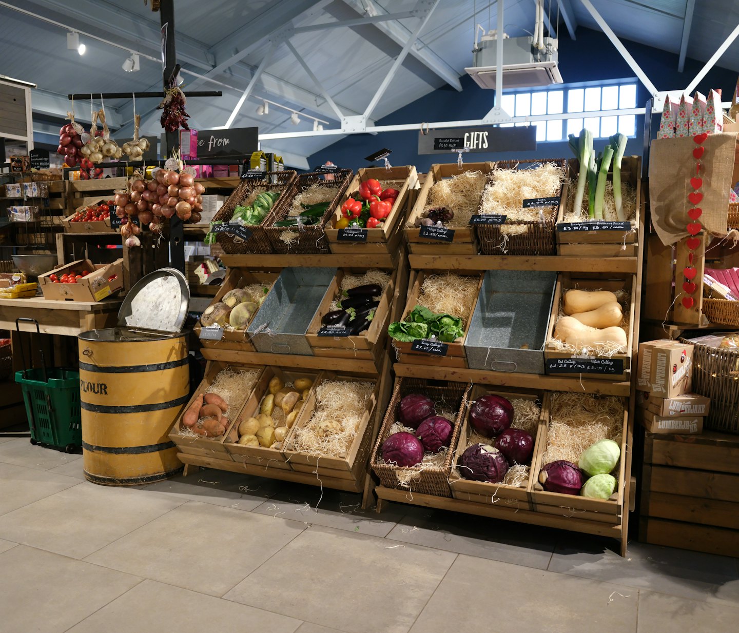 Fresh vegetables arranged on wooden shelves in a farm shop.