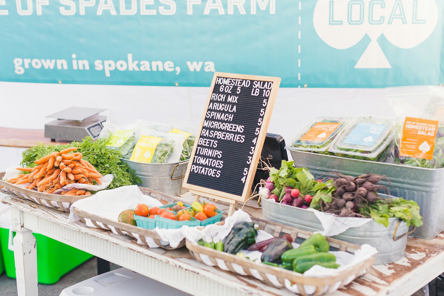 Fresh vegetables and greens displayed at an outdoor farmers market.