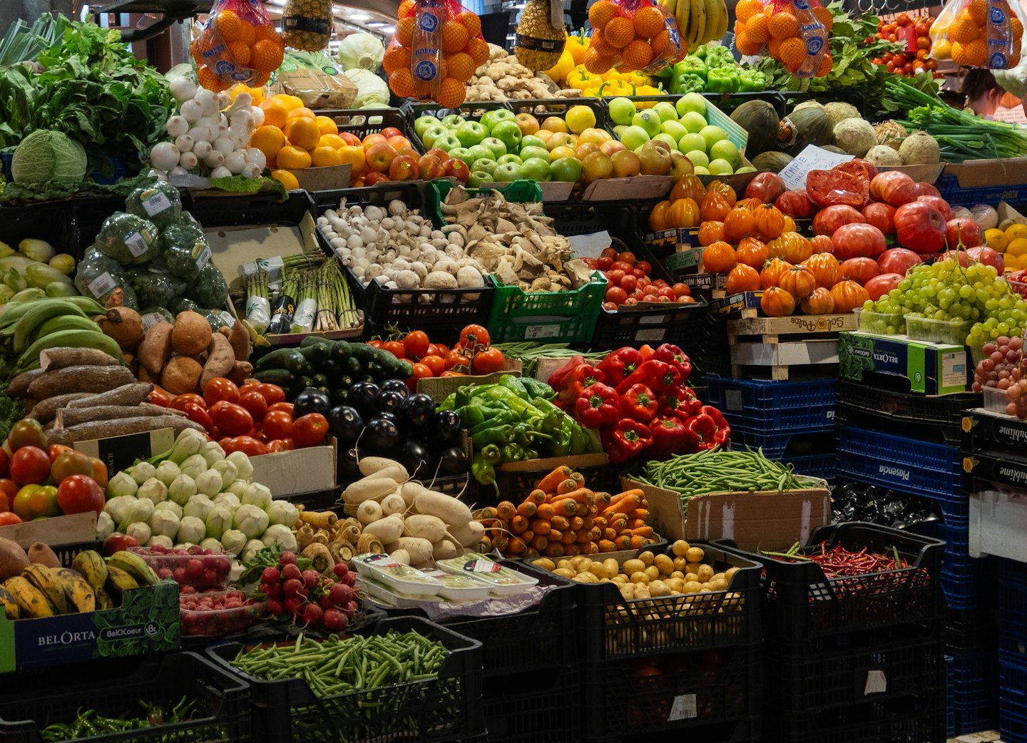 Fresh fruits and vegetables arranged in crates at a market.